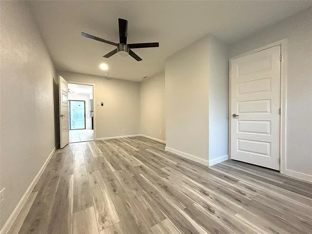 a view of a room with wooden floor and ceiling fan