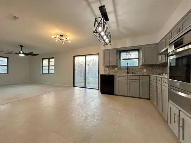 a kitchen with stainless steel appliances granite countertop a sink cabinets and window