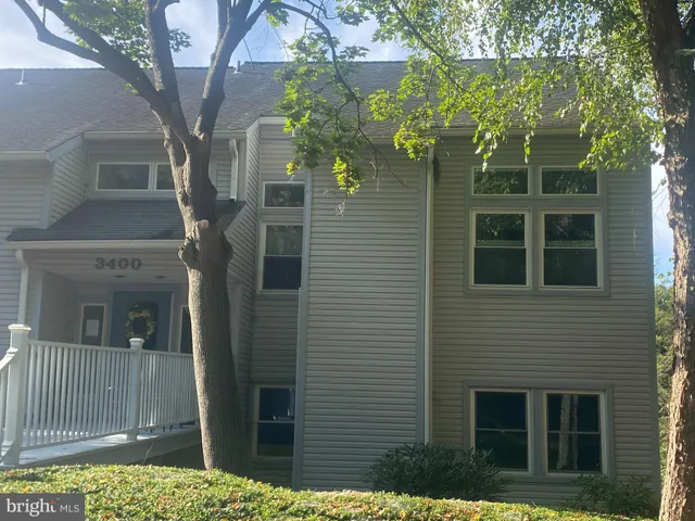 a front view of a house with a tree