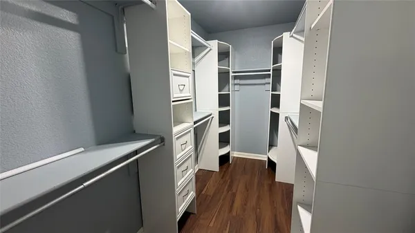a view of walk in closet with wooden floor