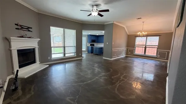 an empty room with windows and fireplace