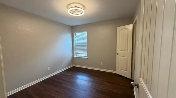 an empty room with wooden floor and window
