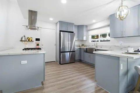 a kitchen with granite countertop stainless steel appliances a refrigerator a sink and cabinets