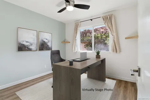 a view of a workspace with furniture and a window