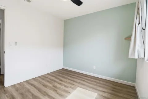 a view of empty room with wooden floor