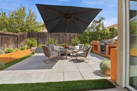 a view of backyard with outdoor seating and wooden fence