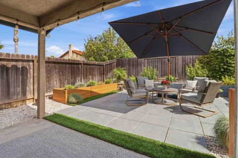 a view of a patio with a table and chairs under an umbrella