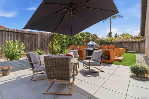 a view of a patio with table and chairs under an umbrella