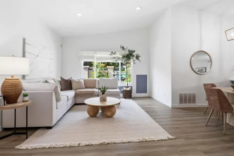 a living room with furniture and a wooden floor