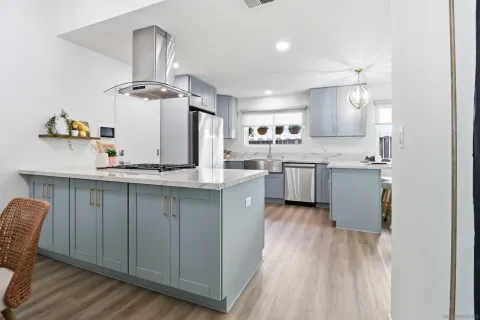a kitchen with kitchen island granite countertop wooden floors and white cabinets