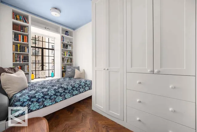 a bedroom with a large bed and a book shelf