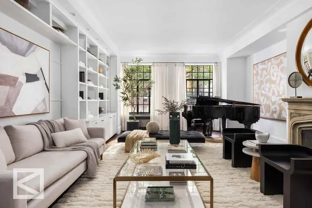 a living room with furniture fireplace and a large window