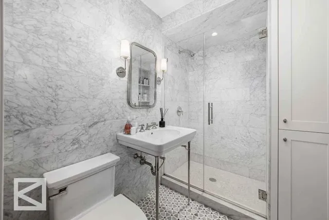 a bathroom with a sink a toilet and shower