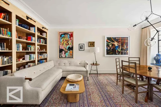 a living room with furniture and a book shelf