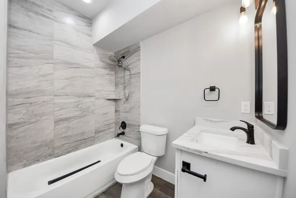 an empty room with wooden floor and ceiling fan