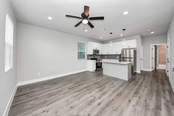a kitchen with refrigerator cabinets and wooden floor