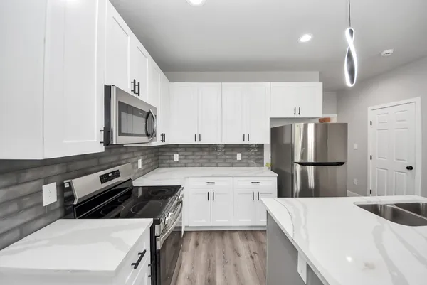 an empty room with wooden floor and ceiling fan
