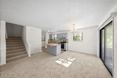 a open kitchen with white cabinets and white appliances