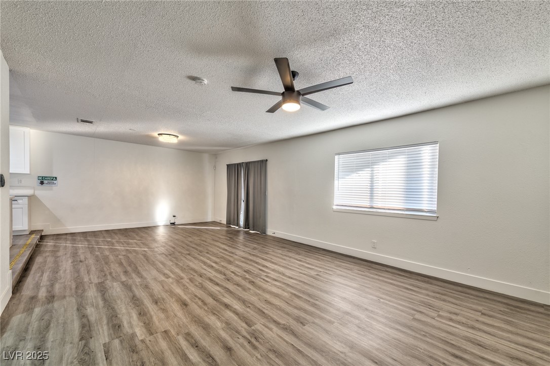 3017 Jamestown Way Las Vegas, NV 89102 - Photo 4 of 15 Unfurnished living room with light wood-style flooring, a textured ceiling, and a ceiling fan