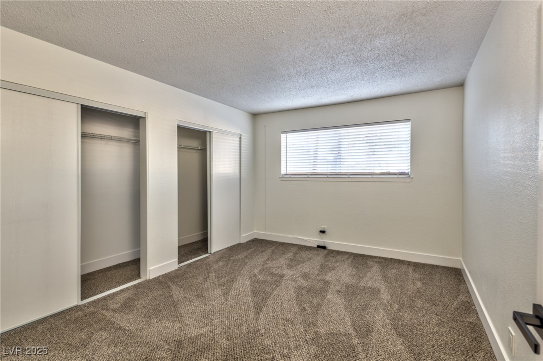 3017 Jamestown Way Las Vegas, NV 89102 - Photo 8 of 15 Unfurnished bedroom with multiple closets, carpet, and a textured ceiling