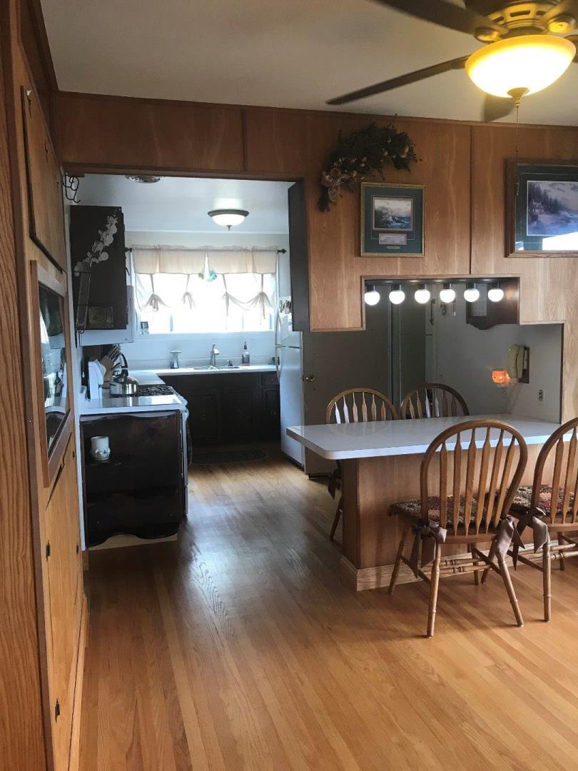 661 Brighton Road Pacifica, CA 94044 - Photo 6 of 18 a kitchen with a dining table chairs and a wooden floor