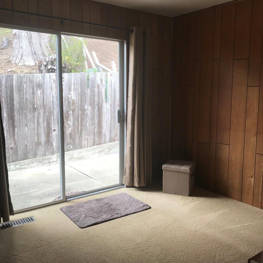 661 Brighton Road Pacifica, CA 94044 - Photo 9 of 18 a bedroom with a bed and glass door