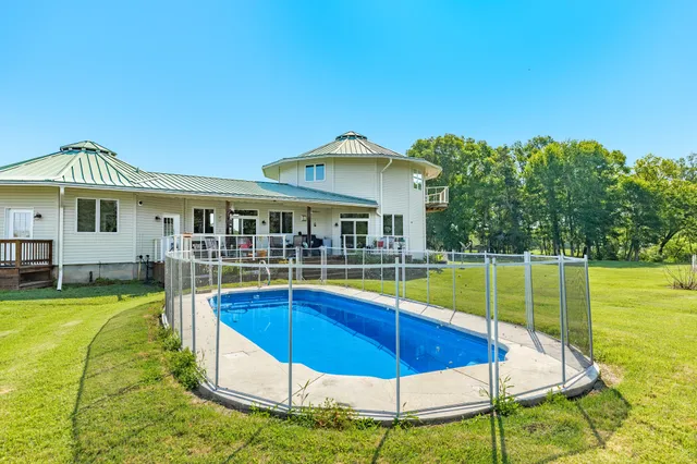 a view of a house with swimming pool and a yard