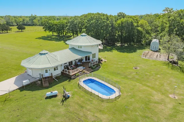 a view of a swimming pool with a patio and a yard