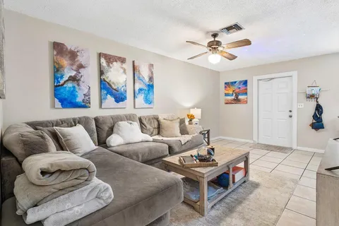 a living room with furniture and a ceiling fan