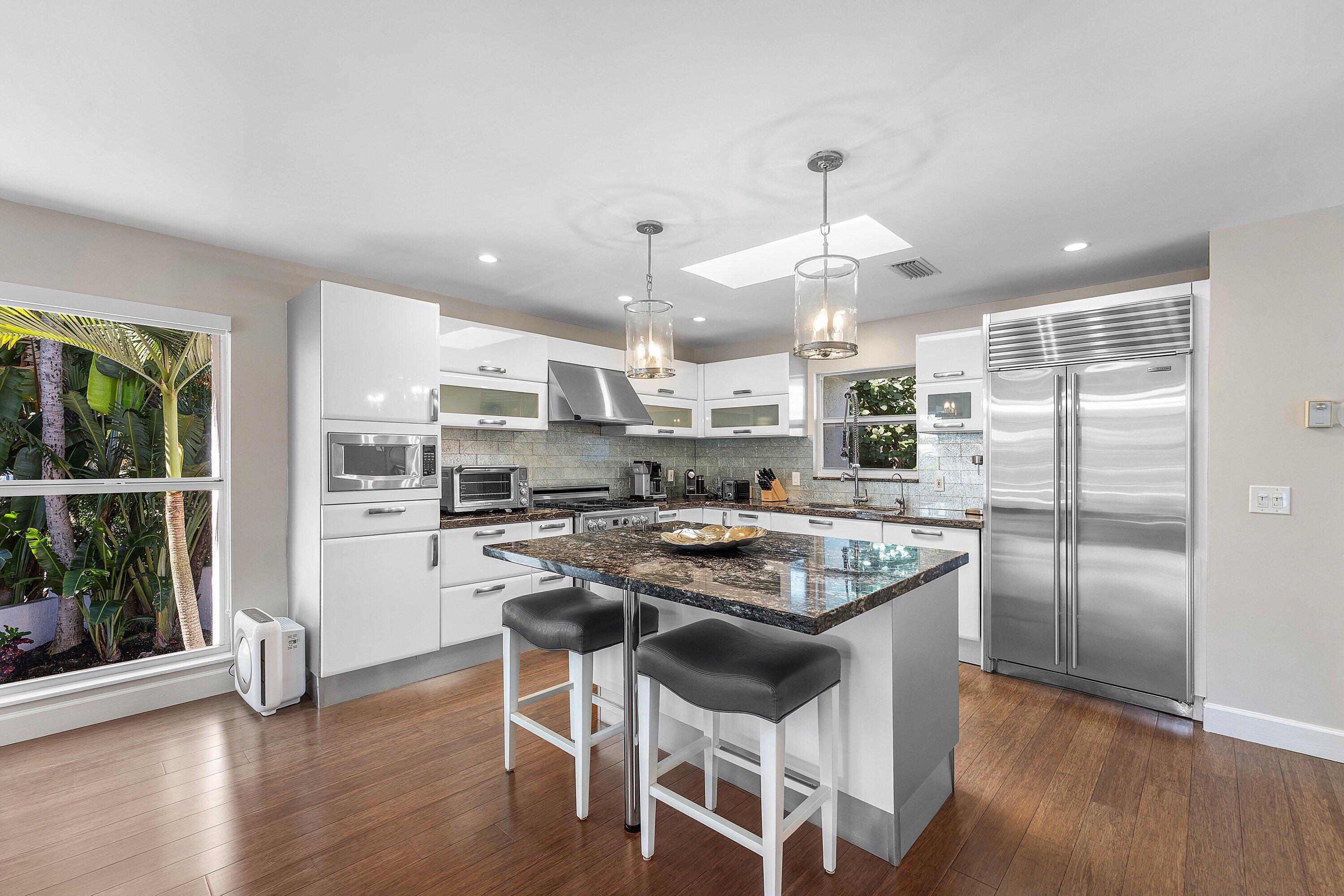 811 Palm Trail Delray Beach, FL 33483 - Photo 13 of 57 a kitchen with stainless steel appliances granite countertop a stove top oven a refrigerator a sink and chairs