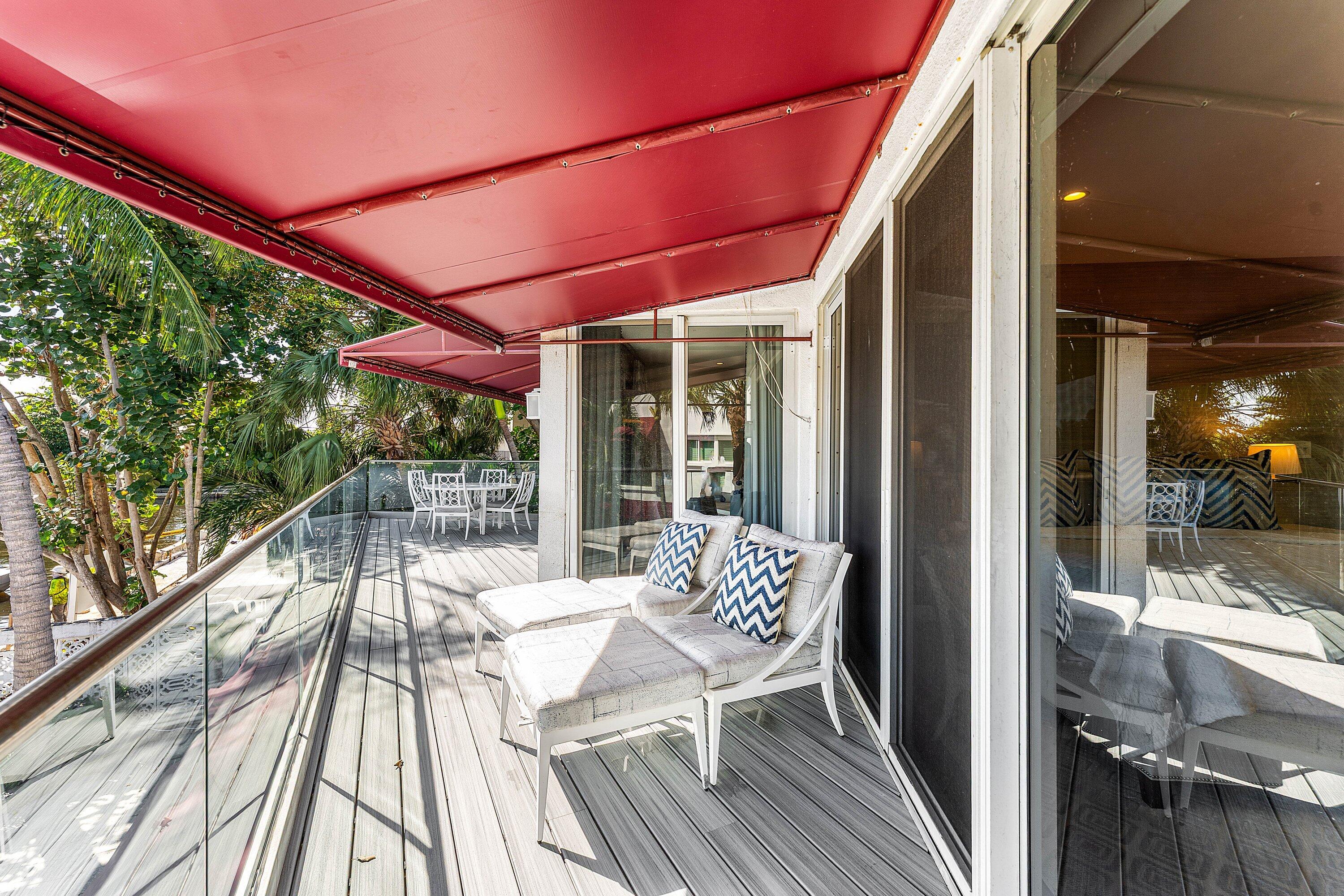 811 Palm Trail Delray Beach, FL 33483 - Photo 17 of 57 a view of a patio with table and chairs under an umbrella with wooden floor