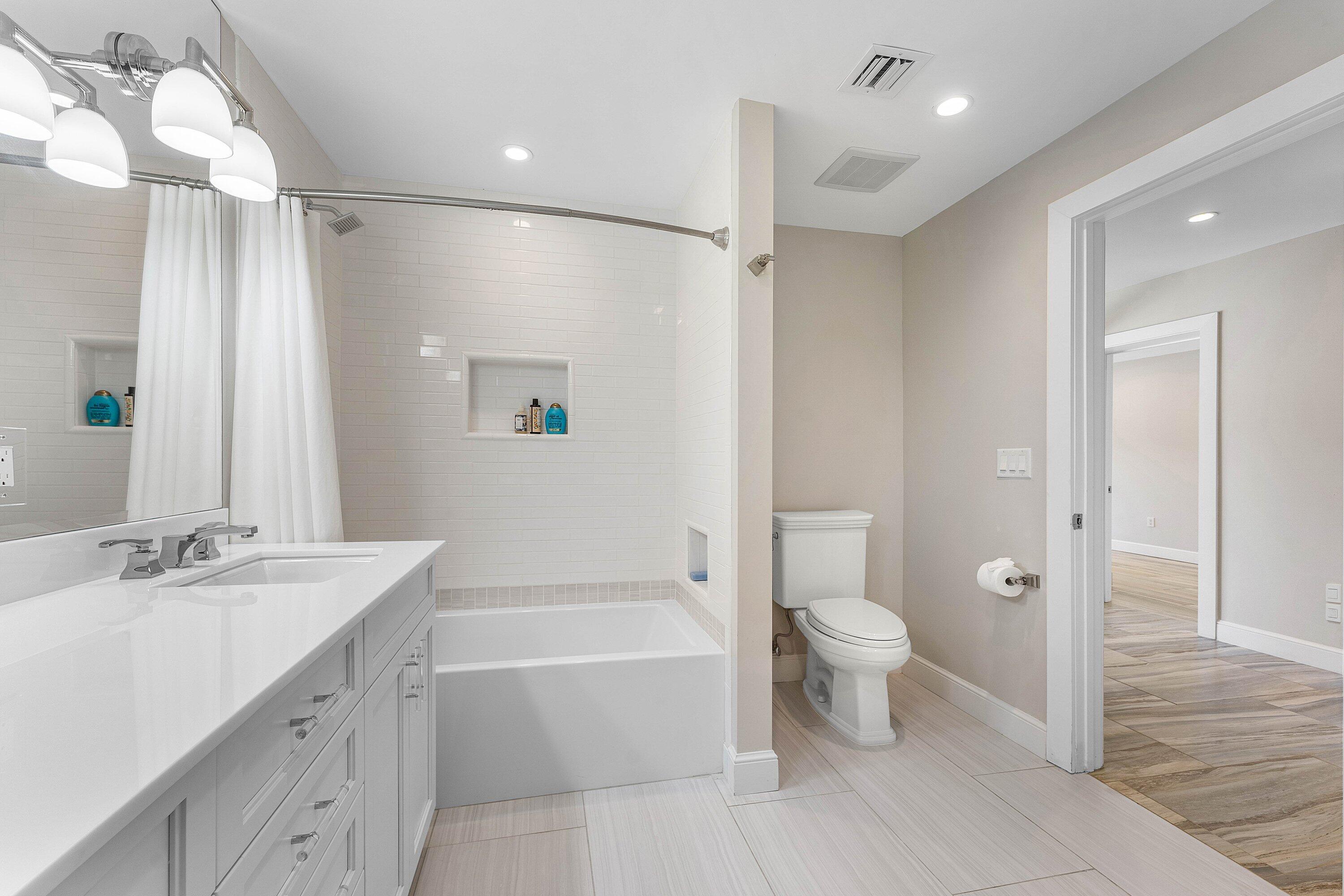 811 Palm Trail Delray Beach, FL 33483 - Photo 28 of 57 a bathroom with a bathtub shower sink vanity and toilet