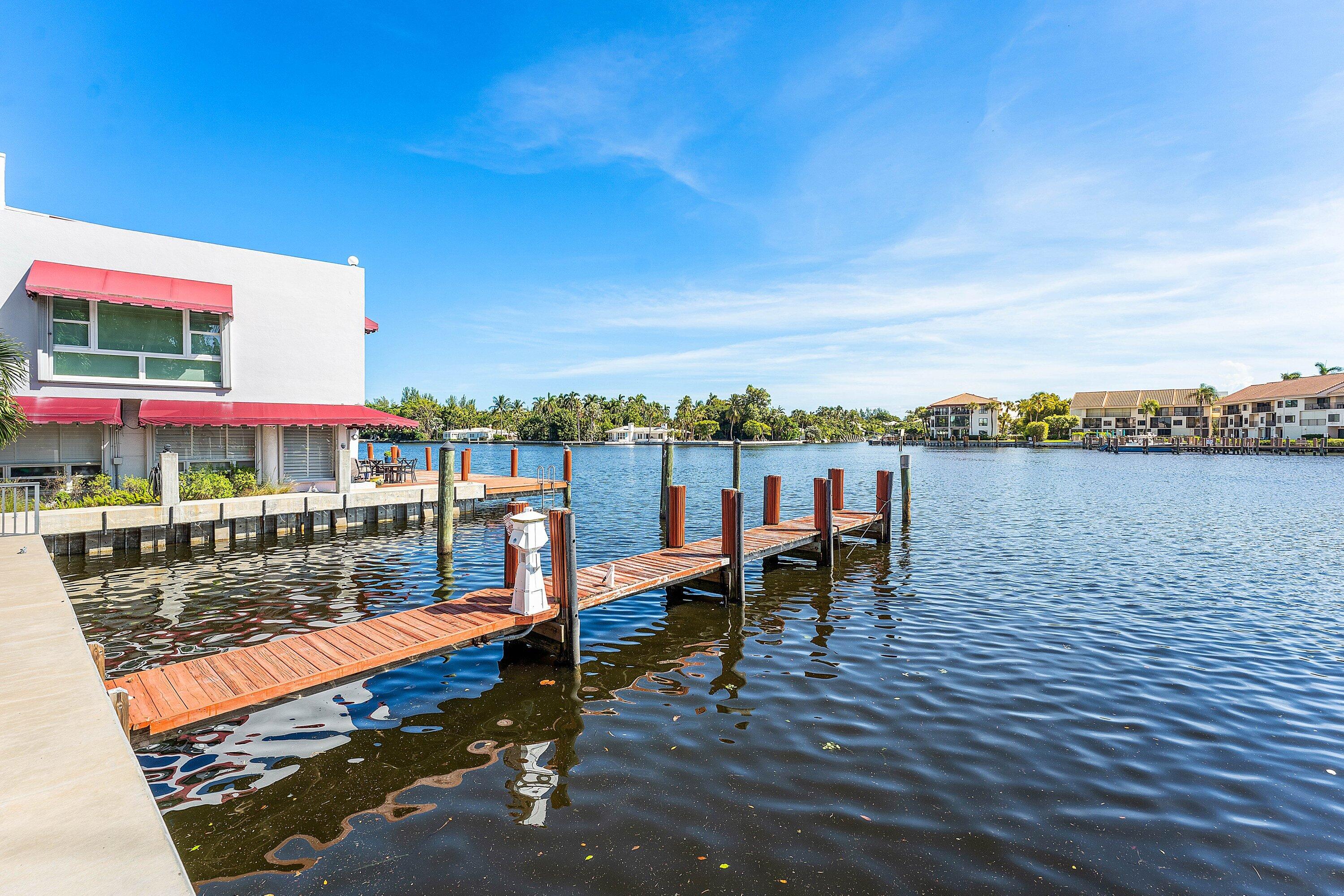 811 Palm Trail Delray Beach, FL 33483 - Photo 40 of 57 a view of a lake with a bench next to a lake