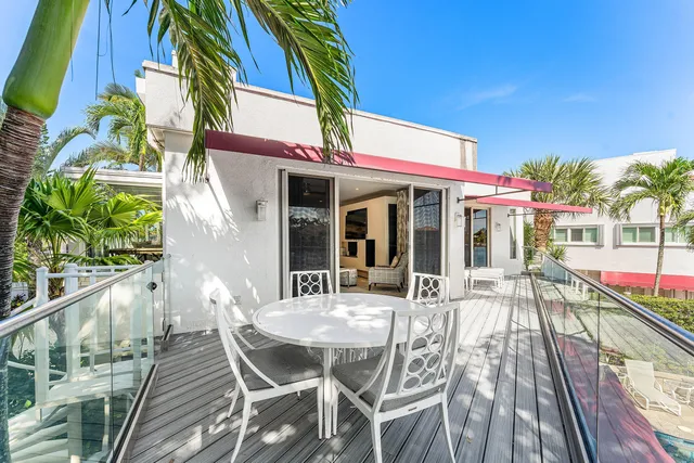 a view of pool with table and chairs under an umbrella