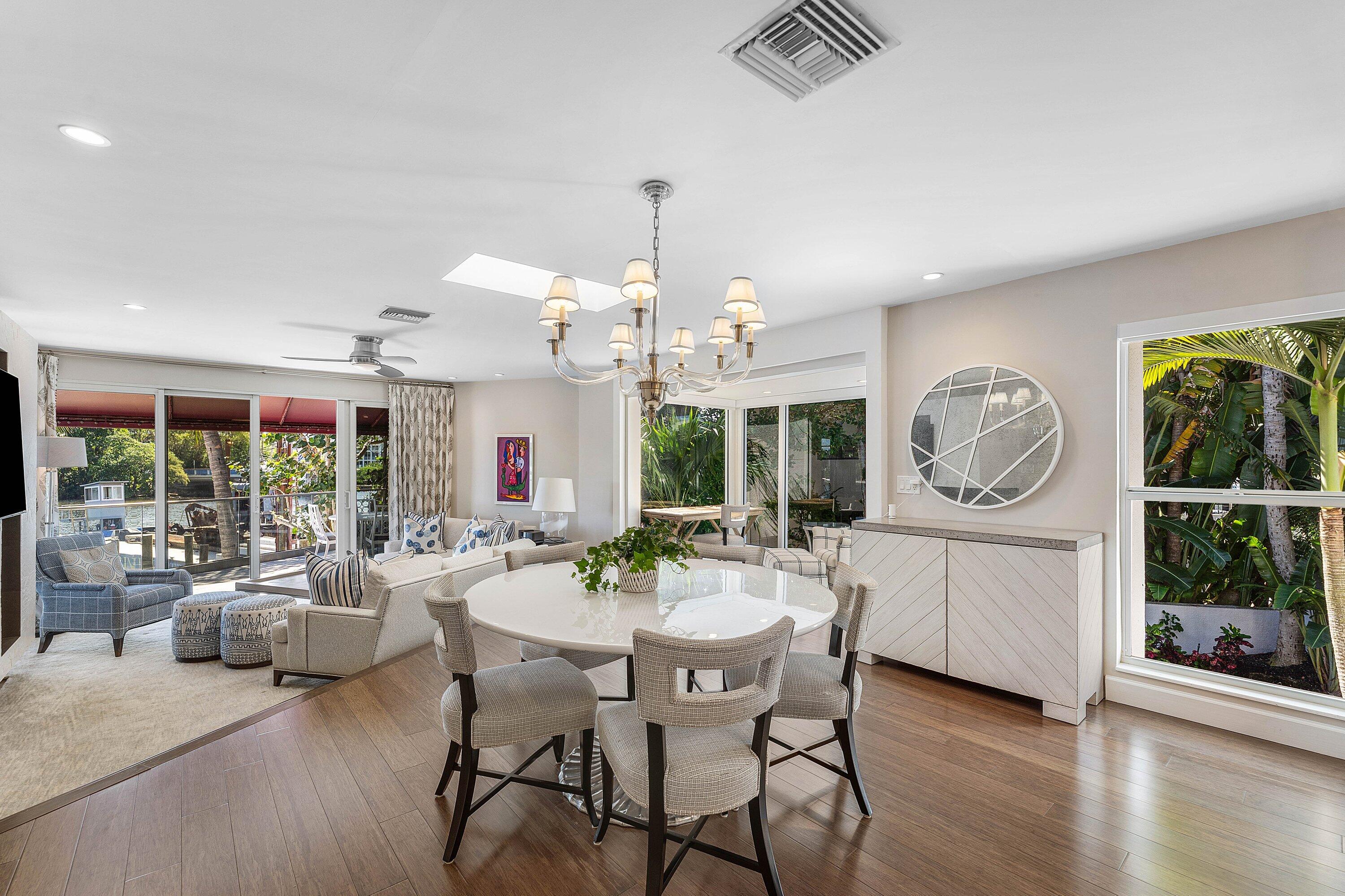 811 Palm Trail Delray Beach, FL 33483 - Photo 6 of 57 a dining room with wooden floor a chandelier a wooden table and chairs