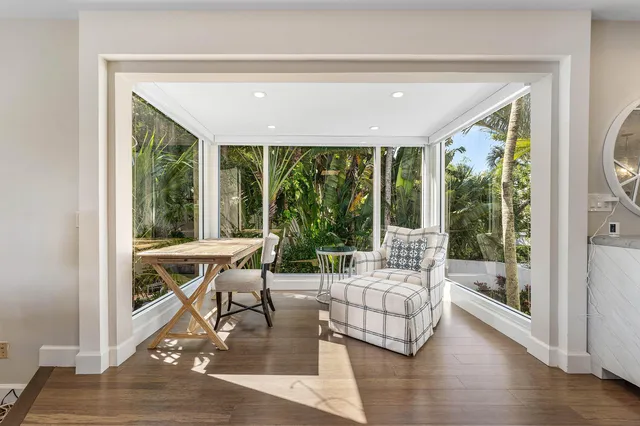 a living room with large windows and wooden floor