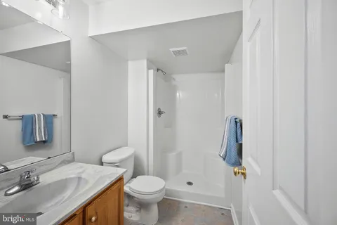 a bathroom with a granite countertop sink toilet and shower
