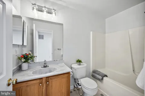 a bathroom with a granite countertop toilet sink and mirror