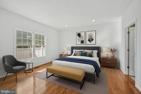 a spacious bedroom with a bed and wooden floor