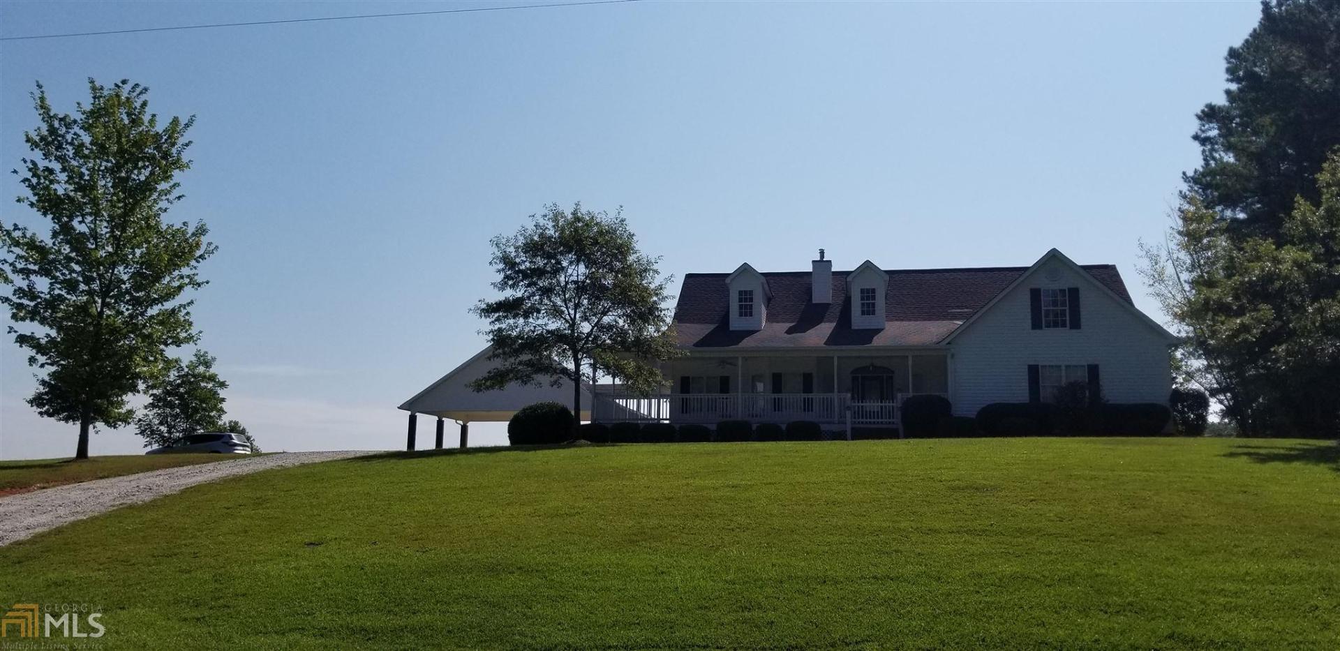 a front view of house with yard and trees in the background
