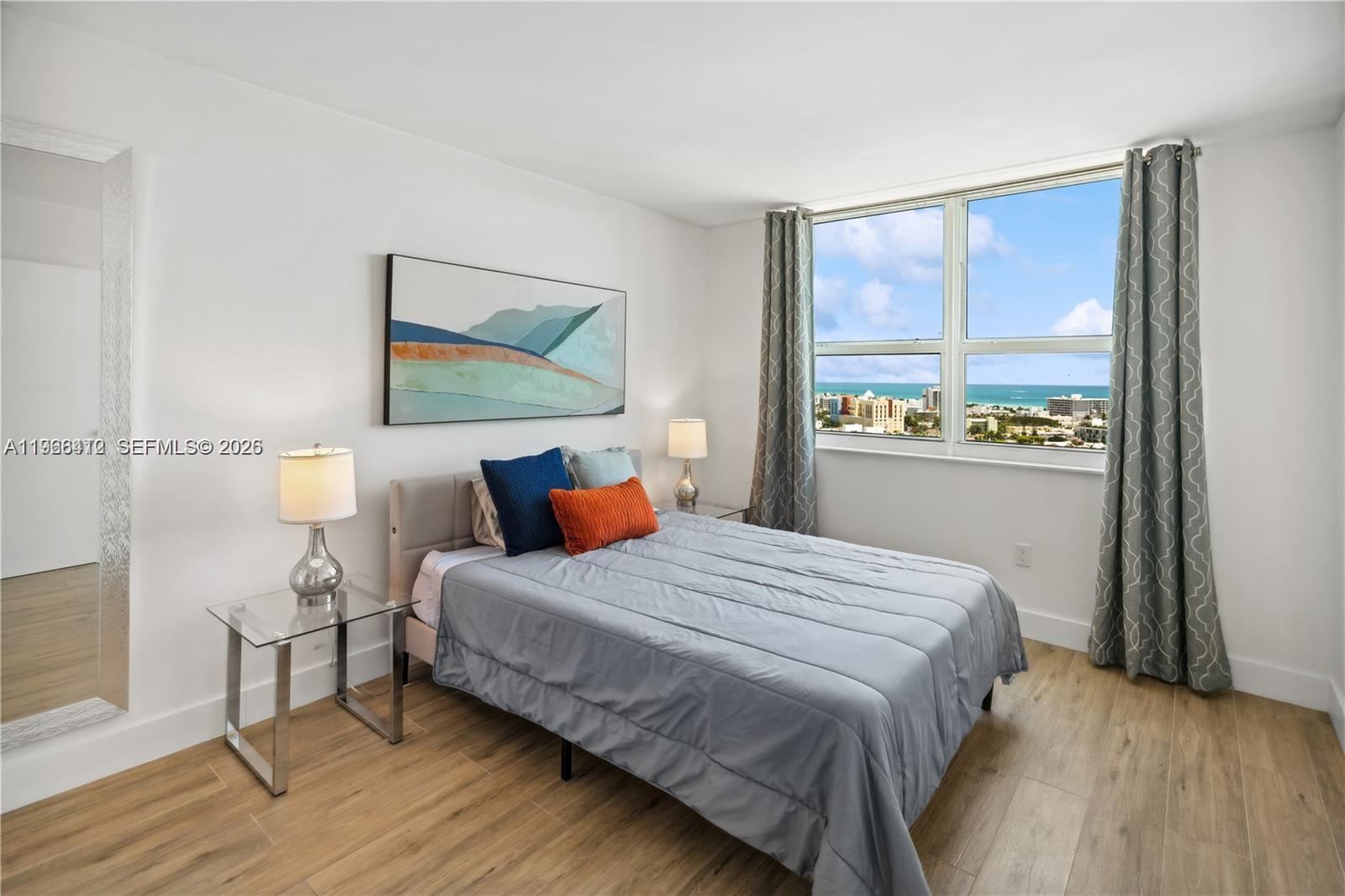 90 Alton Road, Unit 1901 Miami Beach, FL 33139 - Photo 11 of 17 a bedroom with a bed and wooden floor