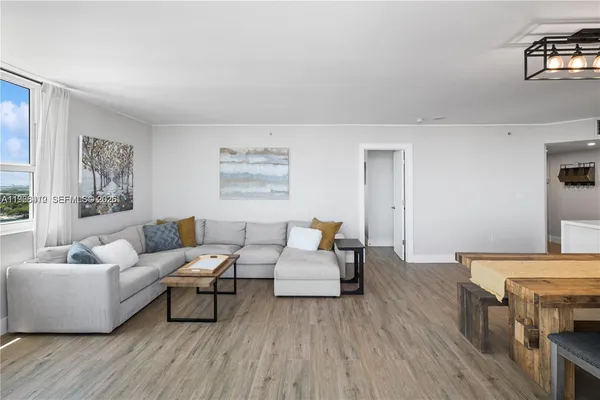 a living room with furniture and a wooden floor