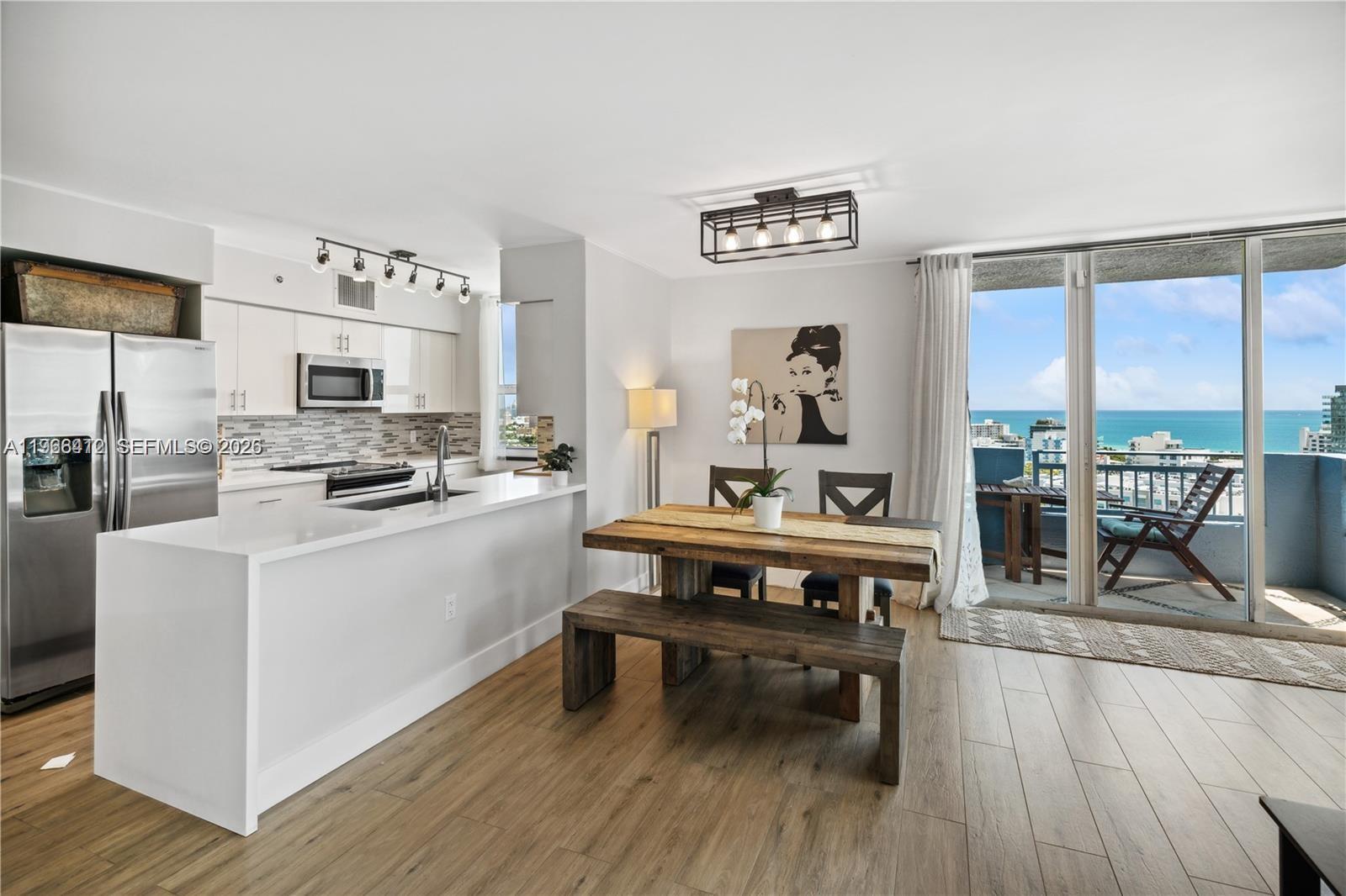 90 Alton Road, Unit 1901 Miami Beach, FL 33139 - Photo 6 of 17 a living room with stainless steel appliances furniture wooden floor and a large window