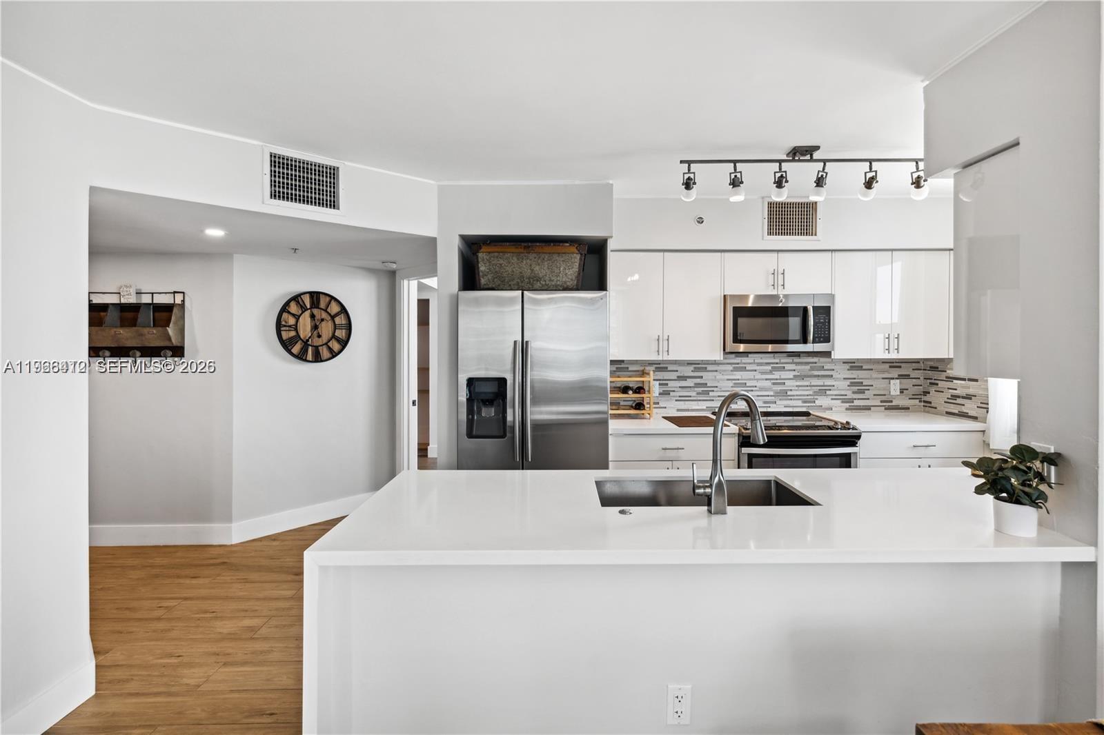 90 Alton Road, Unit 1901 Miami Beach, FL 33139 - Photo 7 of 17 a view of kitchen with stainless steel appliances wooden floor and refrigerator
