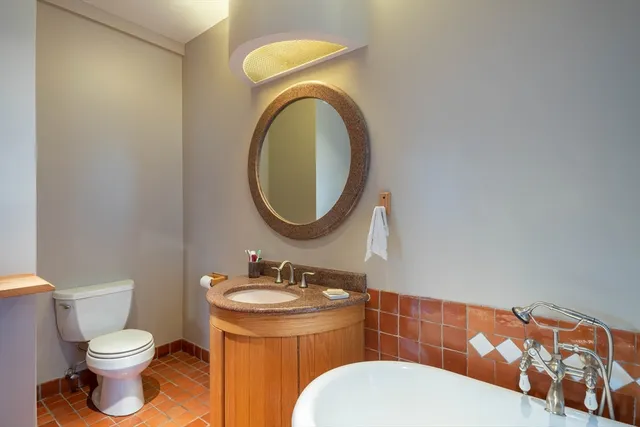 a bathroom with a toilet a sink and a mirror