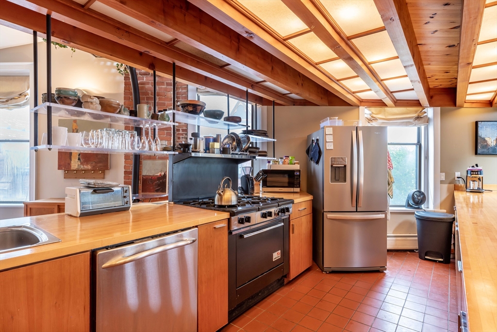 135 Main Street Northampton, MA 01060 - Photo 16 of 28 a kitchen with stainless steel appliances granite countertop a stove a refrigerator and a view of living room