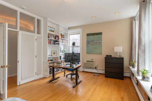 a view of a workspace with furniture and a window