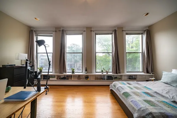 a bedroom with a bed and a large window