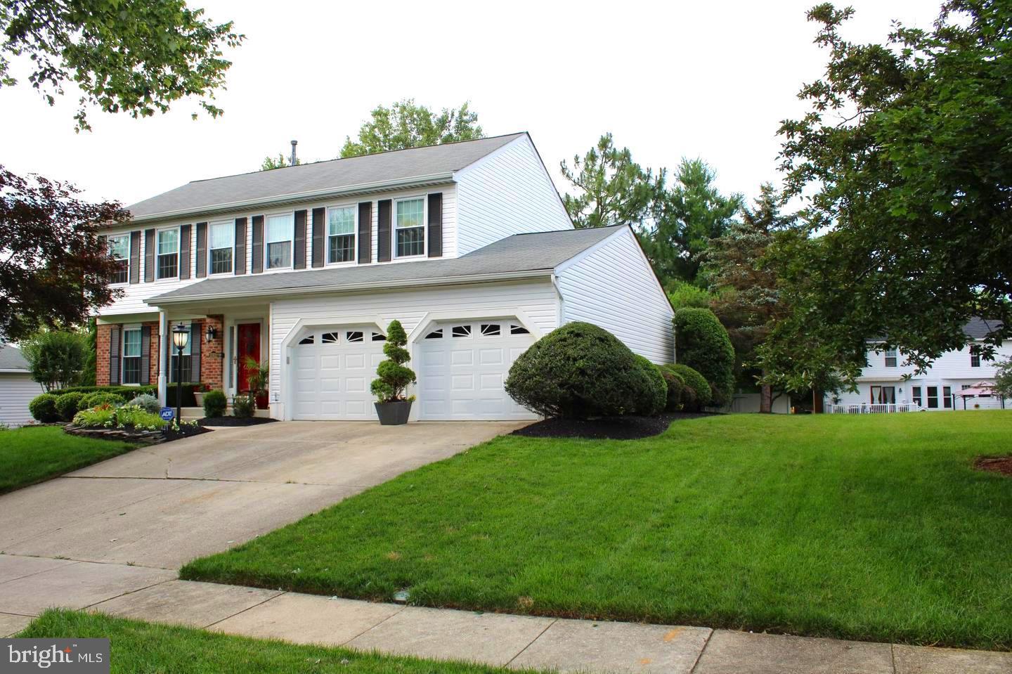 a front view of a house with a yard and trees