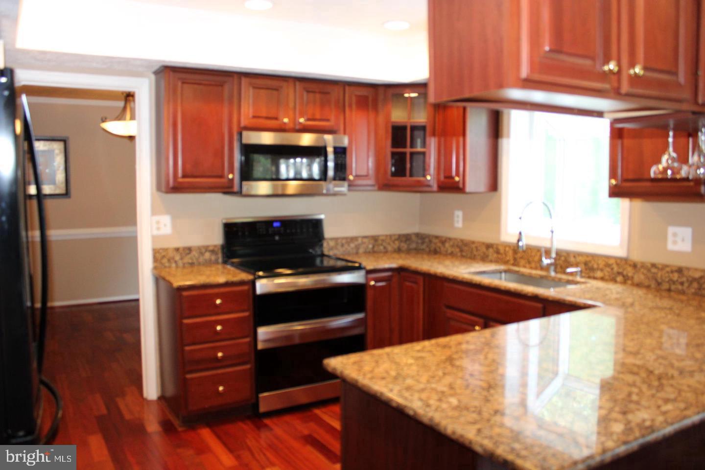 10918 Spyglass Hill Bowie, MD 20721 - Photo 7 of 9 a kitchen with stainless steel appliances granite countertop a refrigerator and a stove top oven